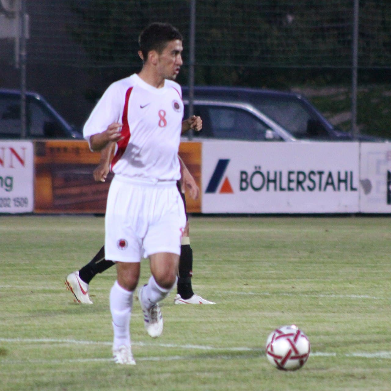 Albanian national football team players in red shirts on a pitch