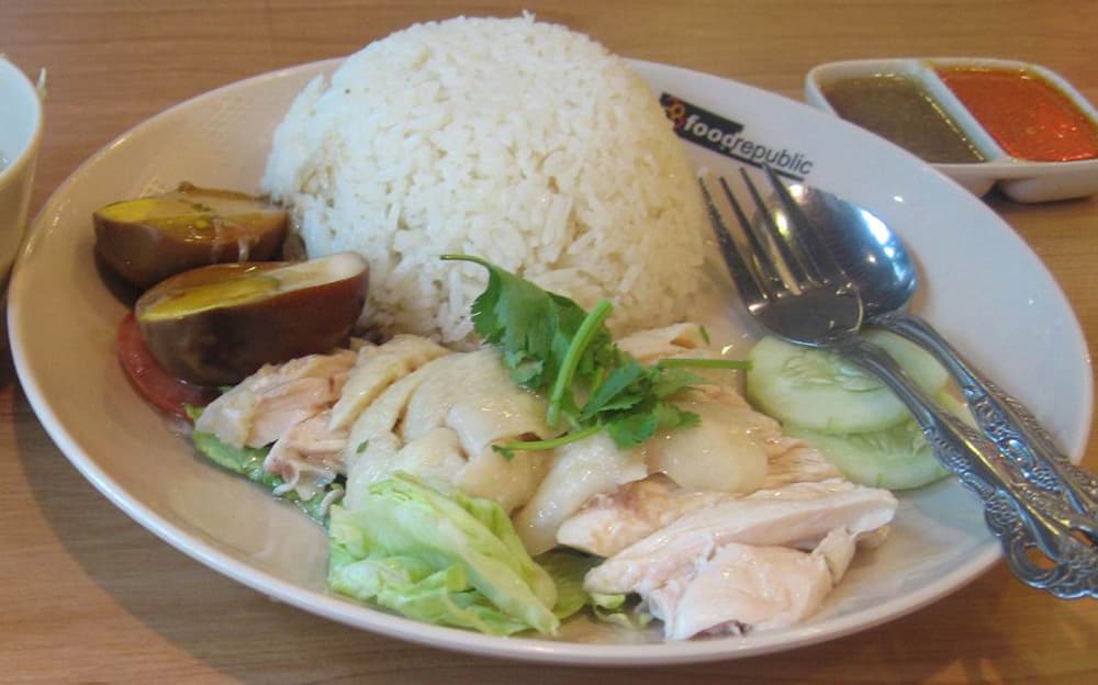 A plate of Hainanese chicken rice with sauces
