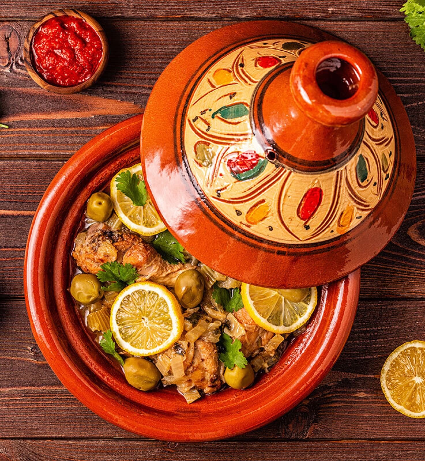 A traditional Moroccan tagine pot with cone-shaped lid steaming on a table